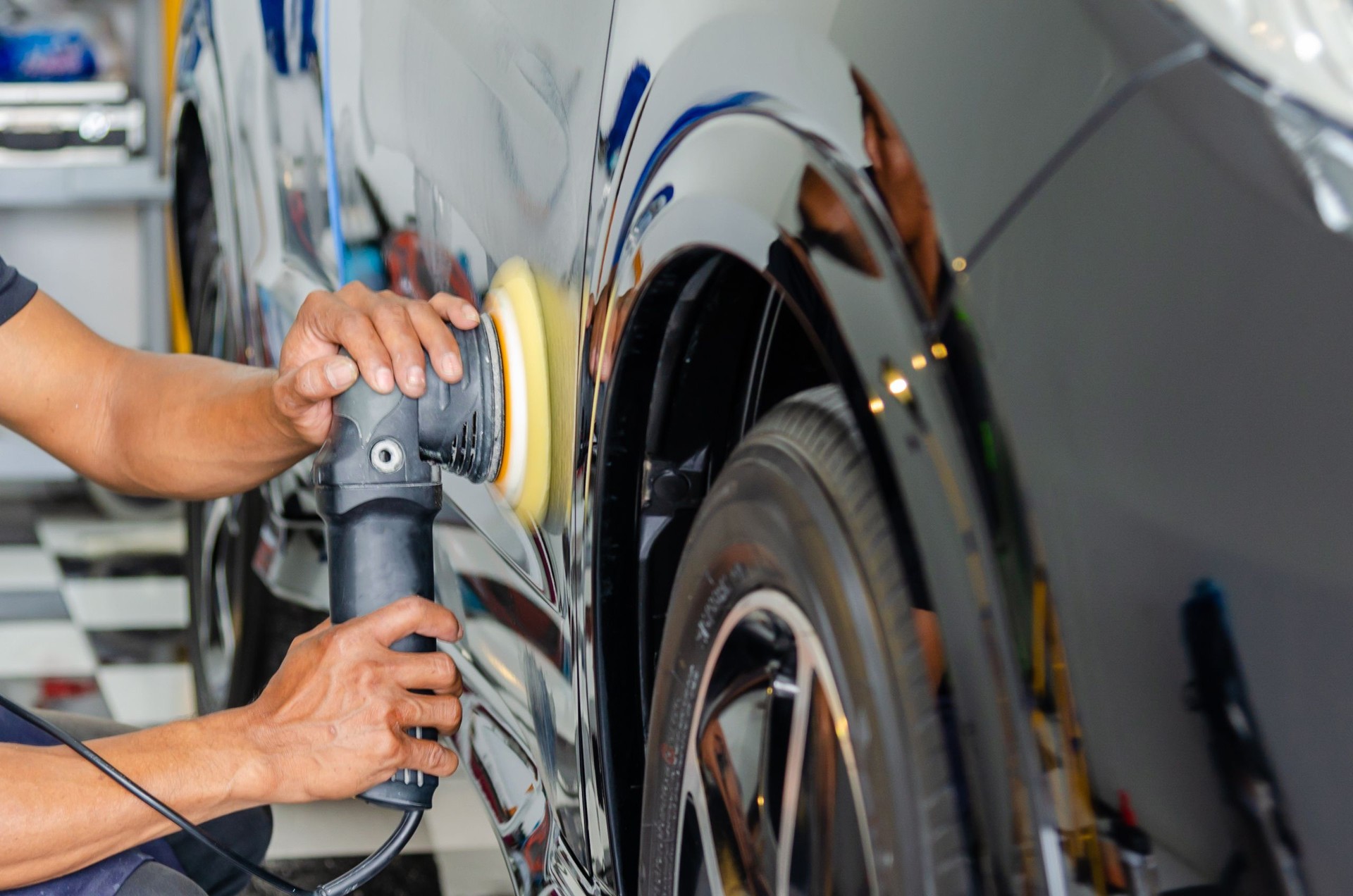 Mann Hände halten das Arbeitswerkzeug polieren das Auto. Buffing und Polieren Auto. Auto Detaillierung.